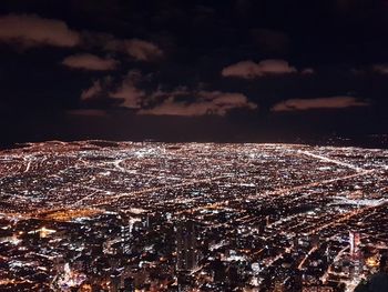 High angle view of illuminated cityscape against sky at night