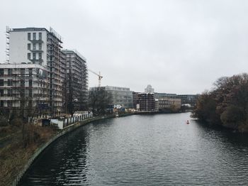 River amidst buildings against sky in city