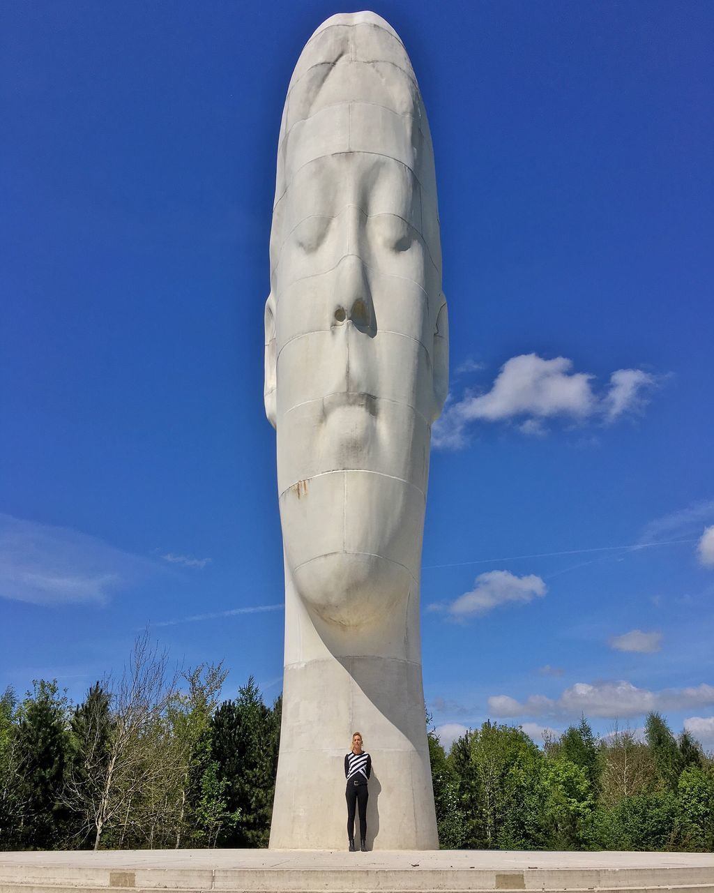 blue, human representation, lifestyles, standing, leisure activity, statue, sky, art, creativity, art and craft, sculpture, full length, front view, tree, day, sunlight, casual clothing