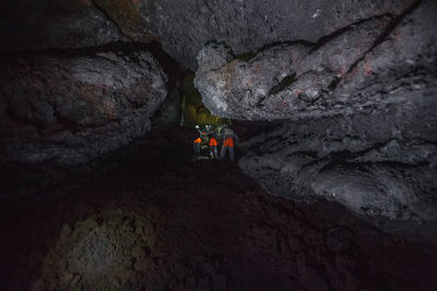 People on rock formation in cave