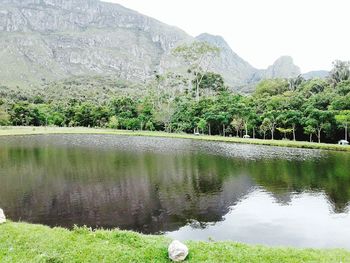 Scenic view of lake by trees against sky