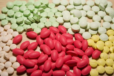 High angle view of colorful medicines on wooden table