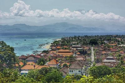 High angle view of townscape by sea against sky