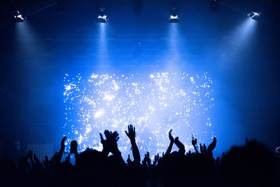 Crowd at a music concert, audience raising hands up