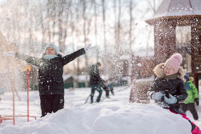 Little girls walks outdoors on winter snowy day in park
