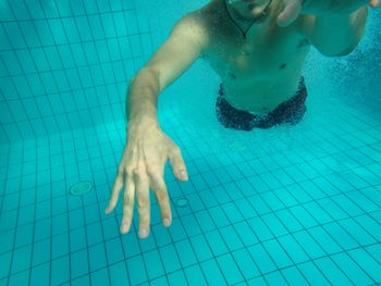 Midsection of man swimming in pool