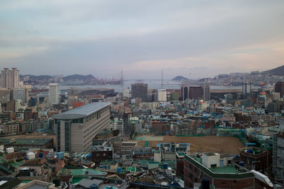 View of cityscape against cloudy sky