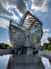 Modern sculpture by lake against sky