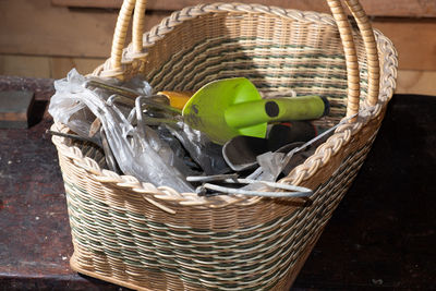 High angle view of wicker basket with plastic green trowel and tent pegs