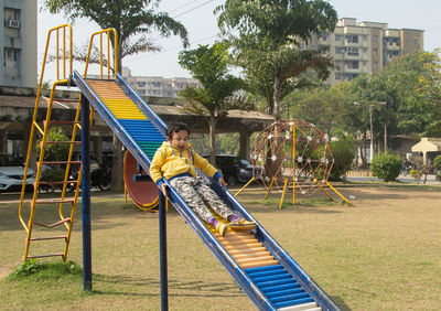 Low section of woman sitting on swing at park