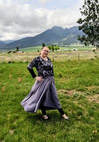 Portrait of woman walking on field against sky