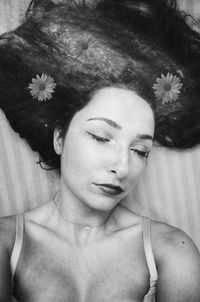 Portrait of young woman lying down on bed