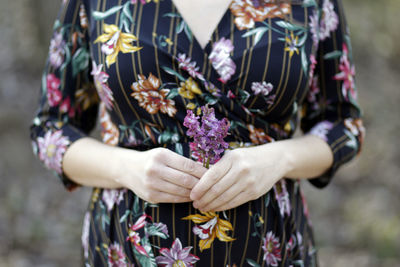 Midsection of woman holding flowering plants