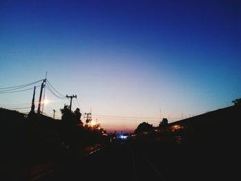 Silhouette of road against sky at sunset