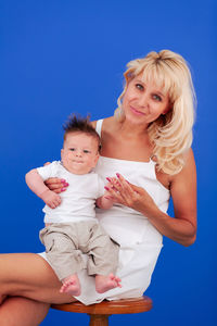 Portrait of mother and son against blue sky