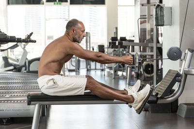 Side view of mature man exercising in gym
