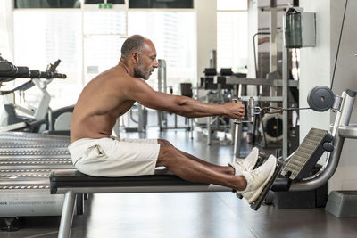 Side view of mature man exercising in gym