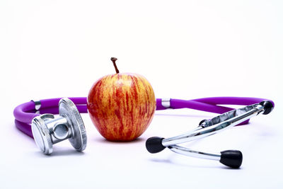 Close-up of apple on table against white background