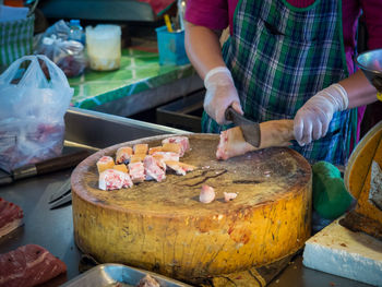 Butcher chopping leg of pig on table at market, chiang mai, thailand