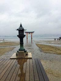 View of pier on beach against cloudy sky