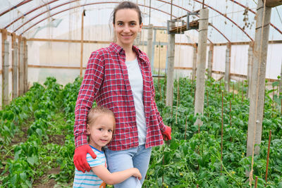 Portrait of boy standing against plants