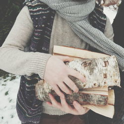 Midsection of woman holding firewood