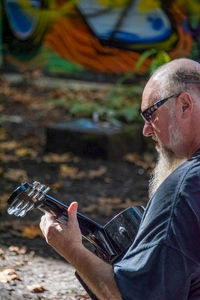 Portrait of man wearing mask holding glass outdoors