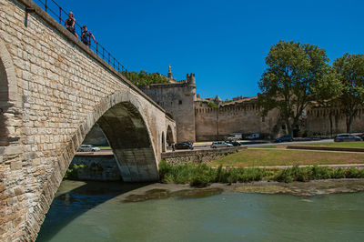 Arch bridge over river against clear blue sky