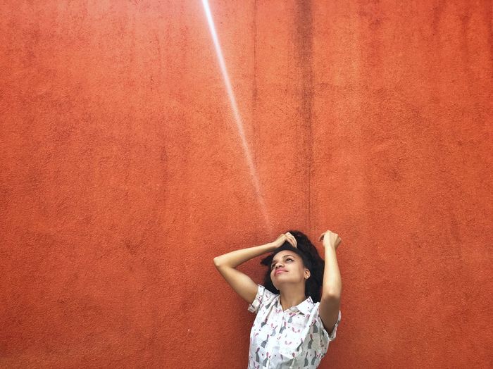 Young woman standing under sunbeam