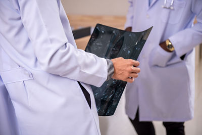 Midsection of doctor holding hands