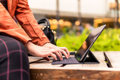 Midsection of man using laptop at table