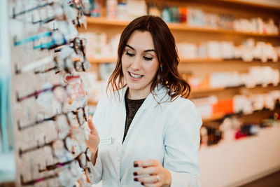 Smiling young woman standing in store