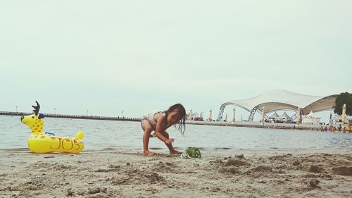 Children on beach against sky