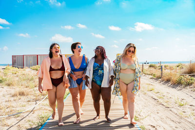 Portrait of smiling friends standing at beach