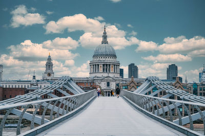 Buildings in city against cloudy sky