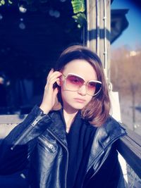 Portrait of young woman wearing sunglasses standing outdoors
