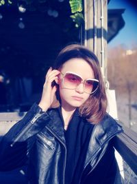 Girl wearing sunglasses while sitting by window