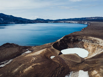 High angle view of volcanic crater by sea