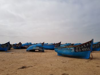 Boats moored on beach against sky