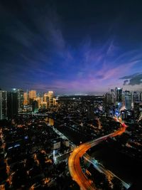 High angle view of illuminated buildings against sky at night