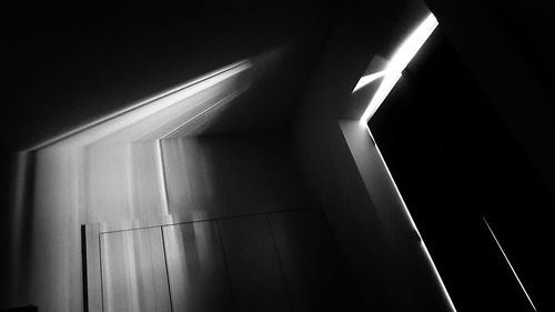 Low angle view of illuminated electric lamp in darkroom