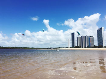 Scenic view of beach and buildings against sky