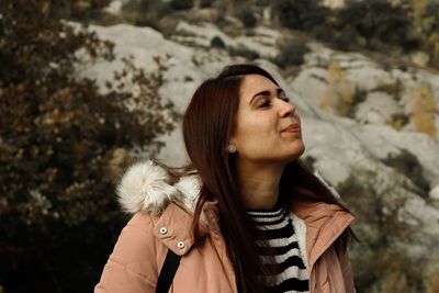 Close-up of woman looking away while standing outdoors