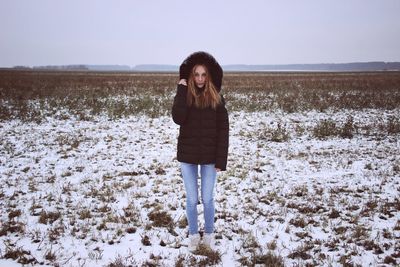 Portrait of woman standing in field during winter