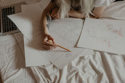 High angle view of man sitting on paper at home