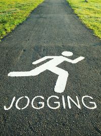 High angle view of pedestrian sign with jogging text on footpath