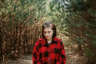 Portrait of young woman standing in forest