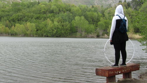 Rear view of man standing on riverbank