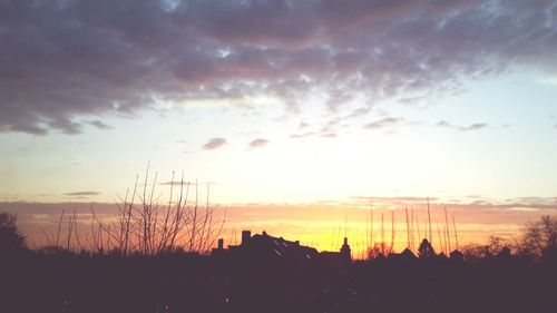 Silhouette cityscape against sky during sunset