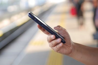 Midsection of man using mobile phone